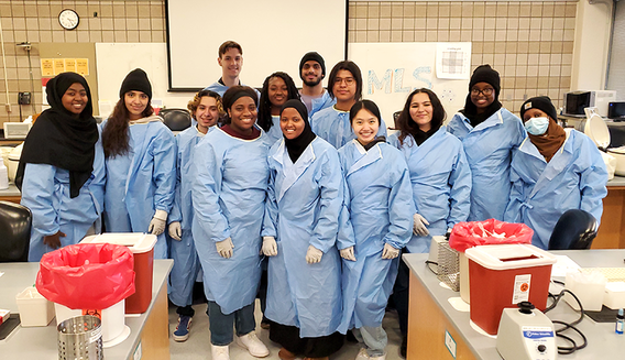 Pathways students in a lab wearing blue scrubs